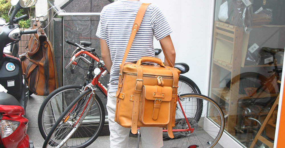 職人手作皮革大型三用旅行後背包，淺棕色，附有雙拉鍊主隔層、前方翻蓋口袋及側邊束帶，風格復古。