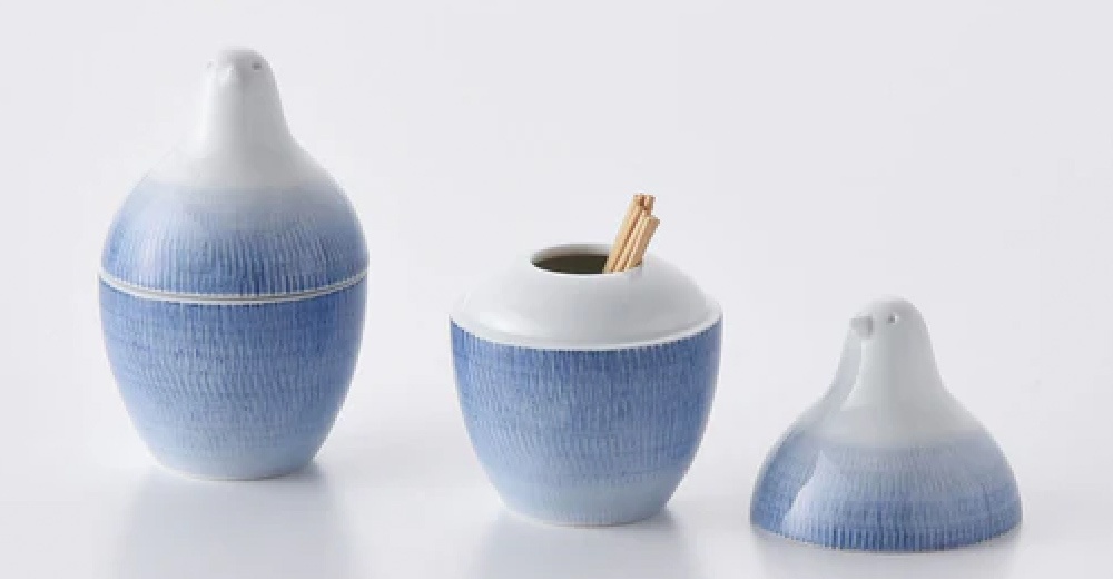 陶瓷牙籤瓶，頂部為白色鳥頭造型，瓶身為藍色漸層條紋，底部有牙籤露出。