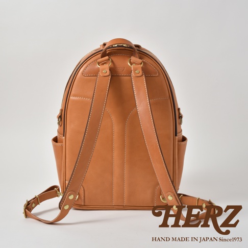 職人手作皮革多功能後背包 R-21，採用棕色皮革製成，設計簡潔，設有雙肩帶、頂部提把及側面口袋，適合日常攜帶。