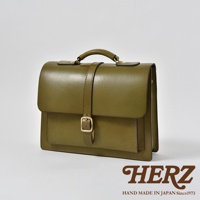 橄欖綠皮革三用單扣商務後背包，帶有金色釦環和手提把，整體風格簡約。