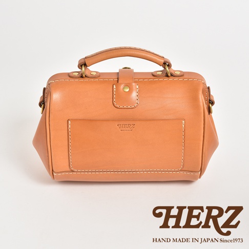 職人手作皮革口金醫生單肩包，淺棕色，配有金色金屬扣和皮質提把。包身採用縫線裝飾，正面有一個方形貼袋，印有品牌標誌。