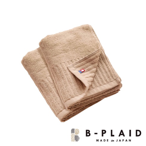 今治長毛柔暖速乾直紋毛巾，呈現米褐色，材質柔軟，織有清晰的直條紋理，角落處有藍紅標誌。