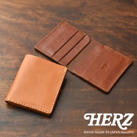 HERZ 職人手作皮革二折式薄型卡片鈔票夾，以溫潤的棕色皮革呈現，縫線細緻，展現日本手工製品的質感。