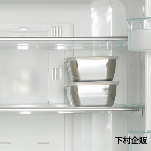 冰箱內部層架上擺放著兩個堆疊的不鏽鋼附蓋調理保存盒，容器呈現簡約的金屬光澤與長方形外觀，右下角標註有下村企販字樣，整體畫面乾淨明亮。