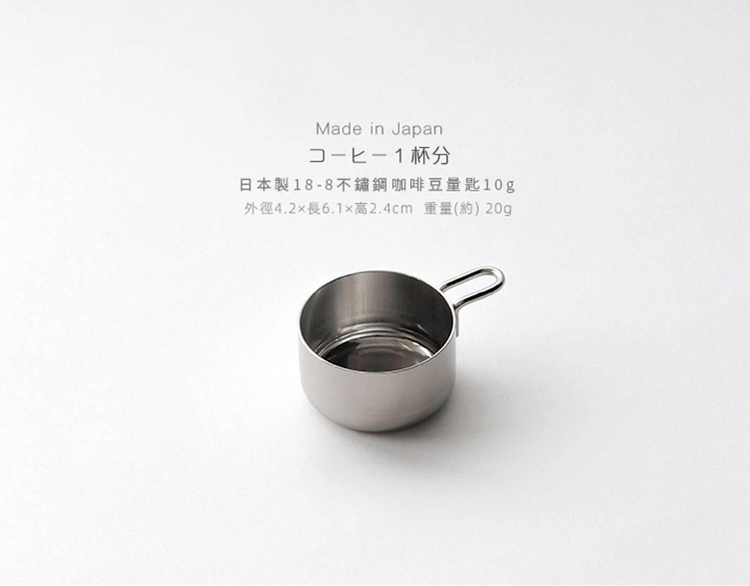 日製18-8不鏽鋼咖啡豆量匙，附有10g標示，呈現銀色金屬光澤，帶有小提把，整體為簡約圓弧造型。