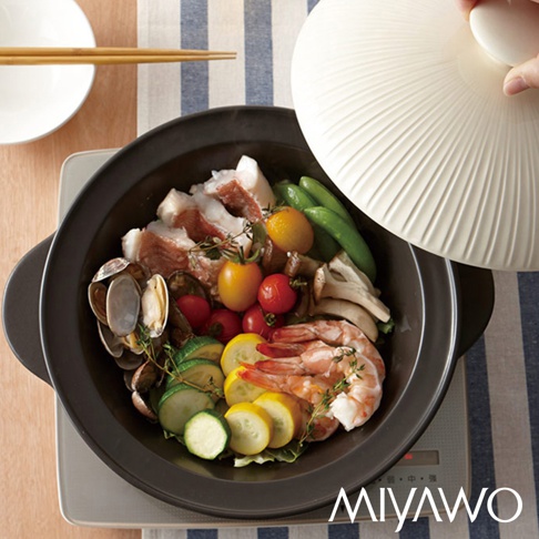 深色陶土湯鍋內盛有豐富的食材，包括豬肉片、蝦仁、蛤蜊、小番茄、櫛瓜、荷蘭豆和菇類，鍋蓋為米白色，帶有放射狀的紋路。