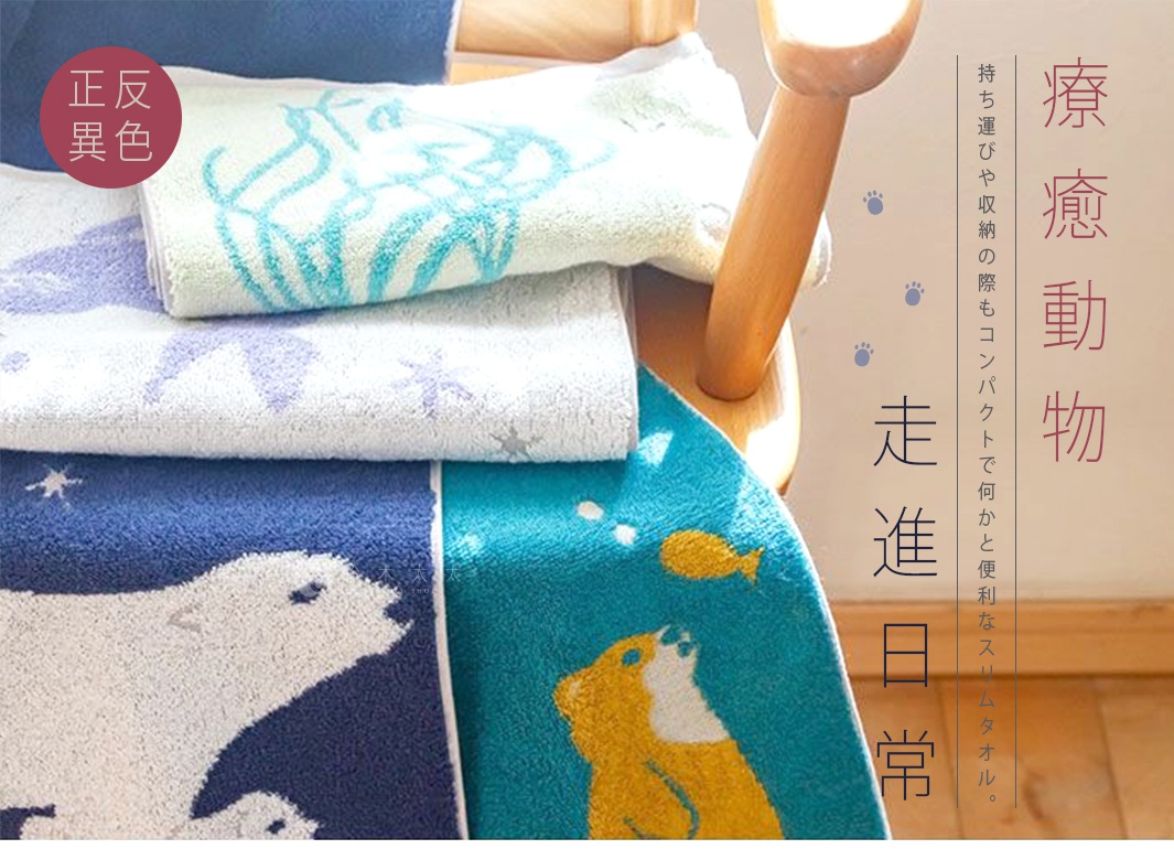 堆疊的毛巾，有藍色、白色和淺綠色，上面印有動物圖案，包括北極熊、狗和魚。