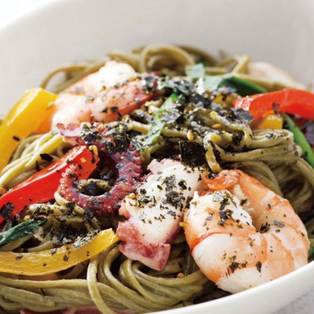 綠色義大利麵搭配章魚、蝦子、紅黃甜椒，撒上黑芝麻與海苔碎。