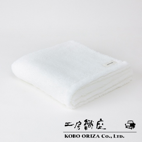 一張摺疊的白色今治柔感極甘撚系匹馬棉浴巾，表面有細緻的絨毛，右上角有一個白色的小織標，下方有「KOBO ORIZA Co., Ltd.」的字樣。
