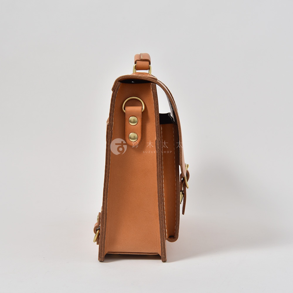 職人手作皮革三用商務後背包，採單扣設計，展示側面，淺棕色皮革，搭配金色五金配件，結構紮實，質感優良。