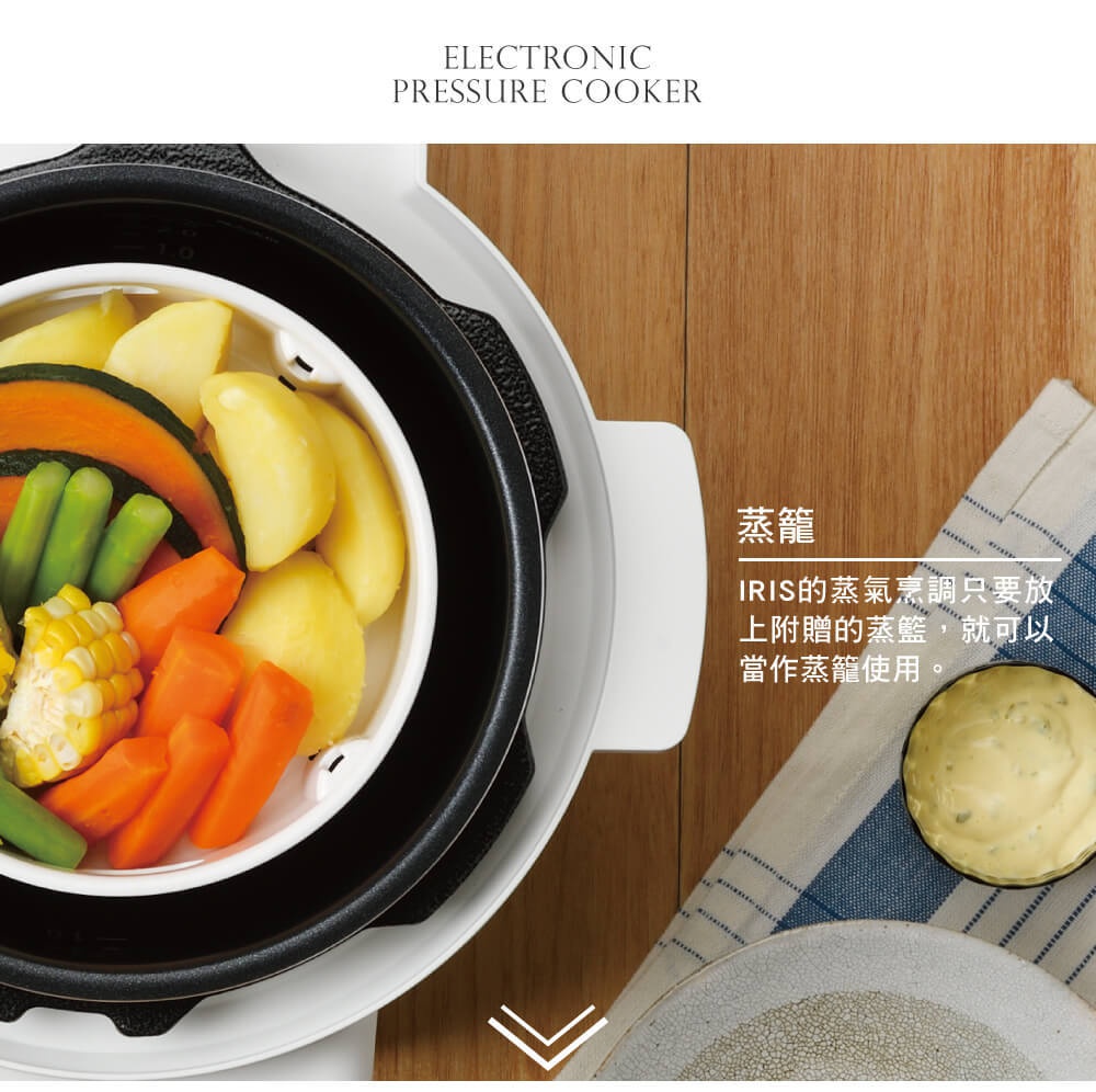 白色電子壓力鍋內盛放著蒸煮的南瓜、馬鈴薯、玉米和綠色蔬菜，呈現豐富的色彩。