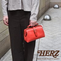 紅色皮革迷你軟皮杜勒斯包，配有金色搭扣和提把，由職人手工製作。