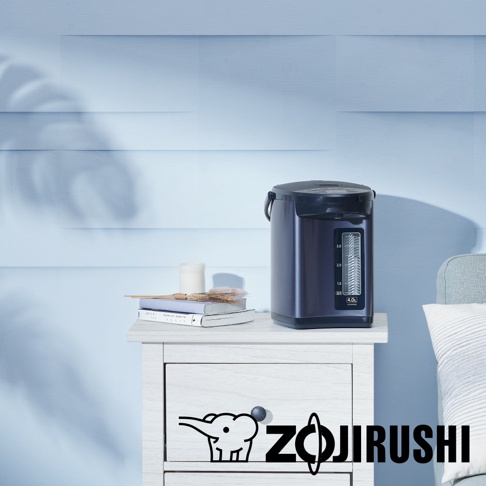 深藍色微電腦電熱水瓶，容量4.0L，帶有透明水位指示器，置於白色木質邊櫃上，旁邊有書本、蠟燭和裝飾物。