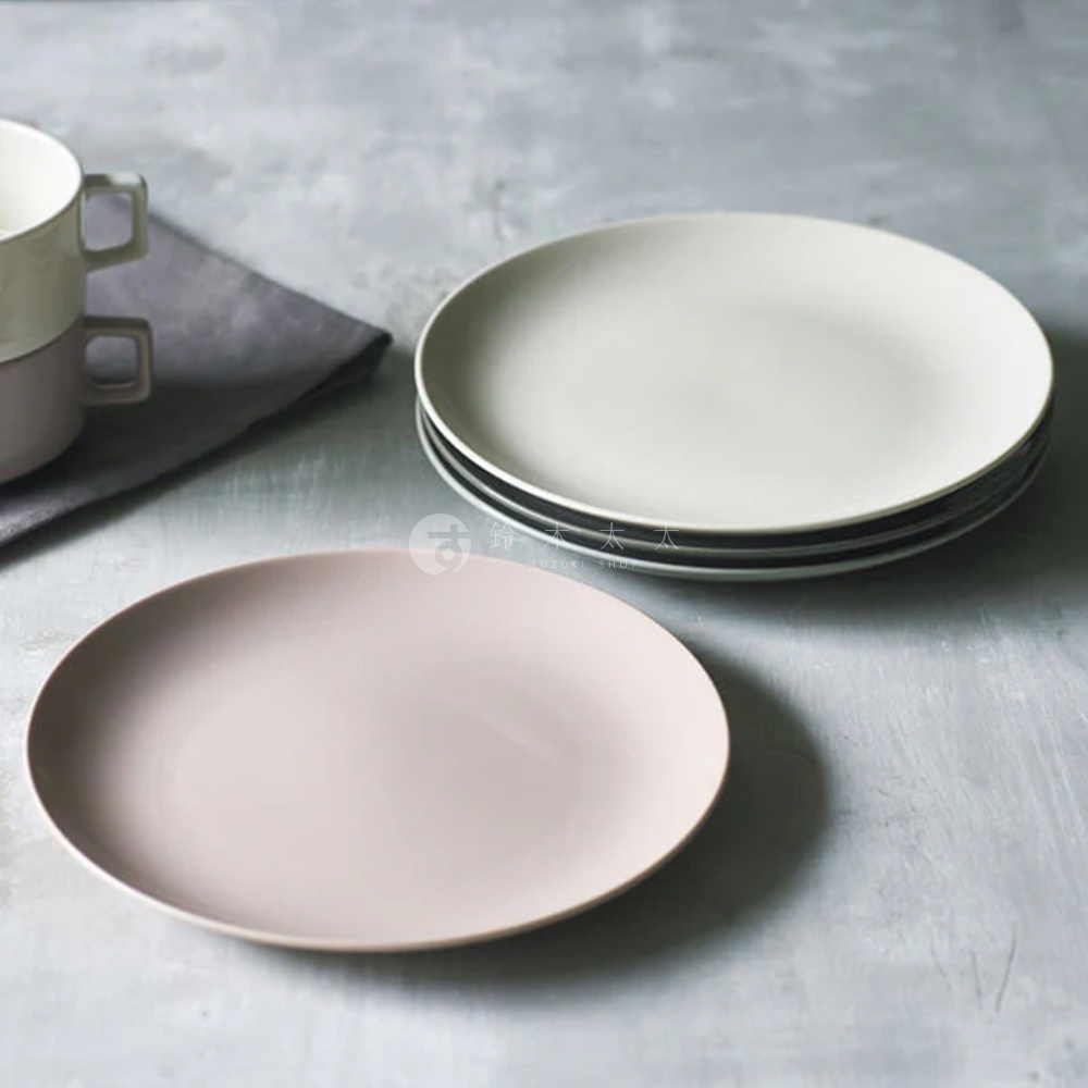 Aito 美濃燒簡約素雅質感圓餐盤，兩個一組，其中一個是粉色，另一個堆疊了三個淺灰色的餐盤，背景是灰色桌面和深灰色布料，還有兩個疊放的杯子。