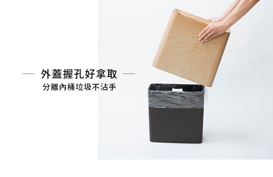 一只手正將淺木色橡木紋的方形外蓋從黑色方形垃圾桶上方提起，內側露出一個黑色垃圾袋。