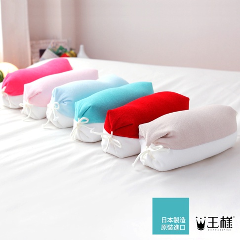 一排顏色鮮豔的糖果枕，包括粉紅色、淺粉紅色、淺藍色、藍綠色、紅色和米色，枕套為柔軟材質，兩端以白色繩子綁緊。