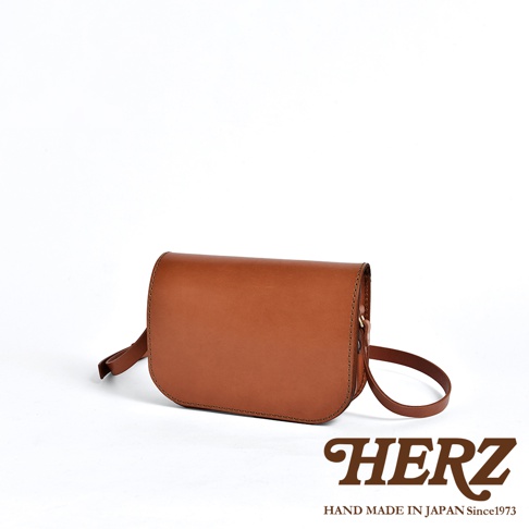 職人手作皮革翻蓋橫式單肩包，採用棕色皮革製成，包身線條簡潔，配有可調節的肩帶，適合日常攜帶。