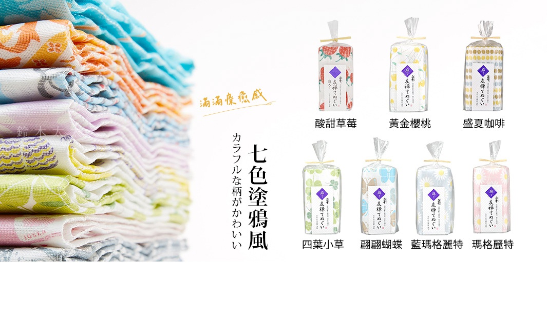 堆疊的友禪染廚房長拭巾，色彩繽紛，有多種植物和昆蟲圖案，材質看起來是棉質，每條拭巾都獨立包裝，展示了草莓、櫻桃、咖啡豆、三葉草、蝴蝶和雛菊等圖案。