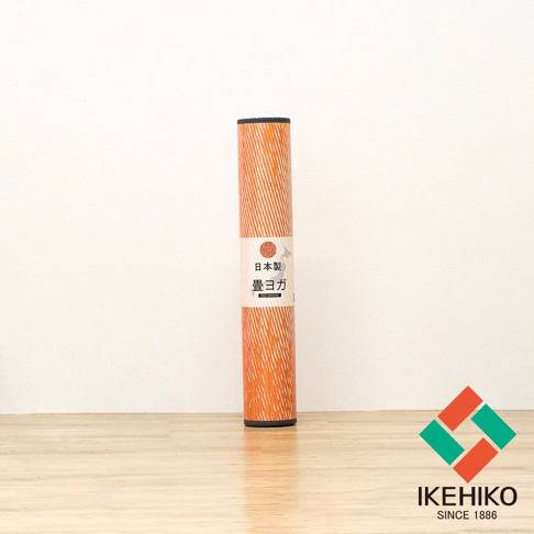 捲起的橘色藺草瑜珈墊，表面有白色細線條紋，標籤印有日文「日本製 畳ヨガ」及「ECO SERIES」字樣。