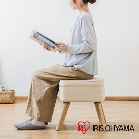 一款淺米色布藝收納椅凳，配有四個木紋椅腳，椅凳頂部可掀開，椅凳側面印有IRIS OHYAMA品牌標誌。