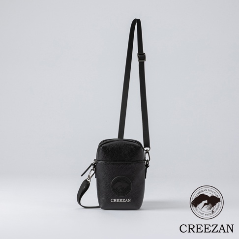 黑色皮革高爾夫迷你側背收納包，包身有圓形壓紋標誌及品牌名稱「CREEZAN」，附有可調節長度的黑色斜背帶。