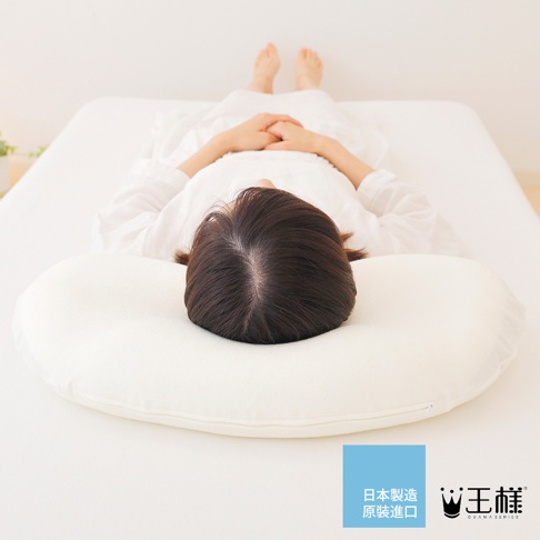 白色柔軟的雲上枕，中央有拉鍊，一位女士仰躺於枕上，頭部後方為深棕色短髮，身穿白色睡衣，雙手交疊於胸前，雙腳露出床單外。