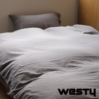 白色棉被搭灰色枕頭，被套上有WESTY品牌浮水印