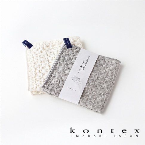 兩條棉麻混紡方巾，一條為白色，另一條為灰色，皆有鬆餅紋理，並帶有品牌標籤。