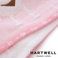 粉色紗布浴巾，繡有白色小狗圖案，邊緣滾有粉色織帶，上面印有白色小爪子圖案。