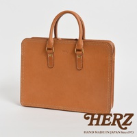 職人手作皮革手提商務公事包，卡其色皮革，簡約方形設計，配有雙提把和金屬扣件，邊緣有白色縫線裝飾。