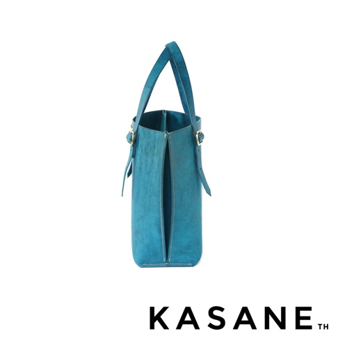 北海道KASANE品牌職人手作義大利Margot皮革托特包No.43，藍色水桶包側視圖，包款頂部有提把，側面有可調整的皮帶扣。