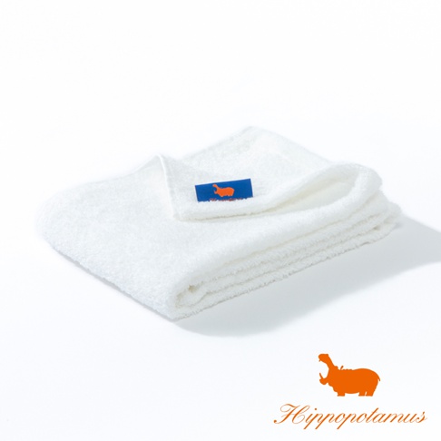 白色竹棉混紡毛巾，質地厚實柔軟，左上角有藍色標籤，印有橘色河馬圖案。