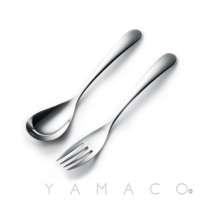 一組光滑的銀色不鏽鋼叉子和湯匙，以優雅的白色背景呈現。