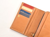 職人手作皮革中型雙折短夾，淺棕色，內含多個卡槽，可放入數張卡片，並附有拉鍊隔層。