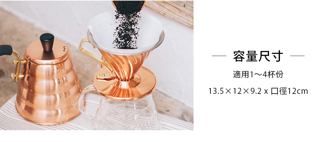 銅製V60濾杯，帶有金色把手，正置於玻璃咖啡壺上，濾杯中正倒入咖啡粉。