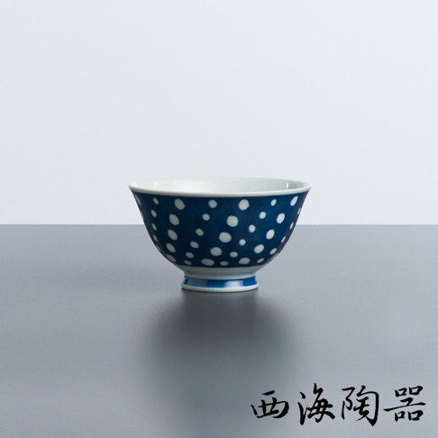 一個深藍色陶瓷飯碗，碗身佈滿白色圓點紋飾，碗口邊緣和底部有藍色條紋裝飾。