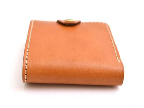 棕色皮革短夾，有縫線細節和金色按扣。