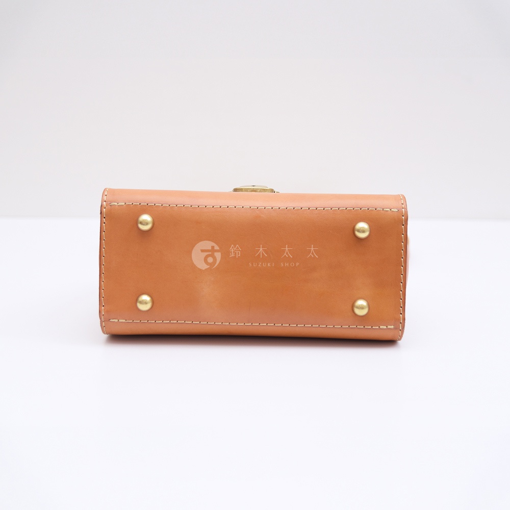 HERZ 職人手作皮革包底部，設有四個金屬腳釘，中央印有品牌標誌與 SUZUKI SHOP 字樣