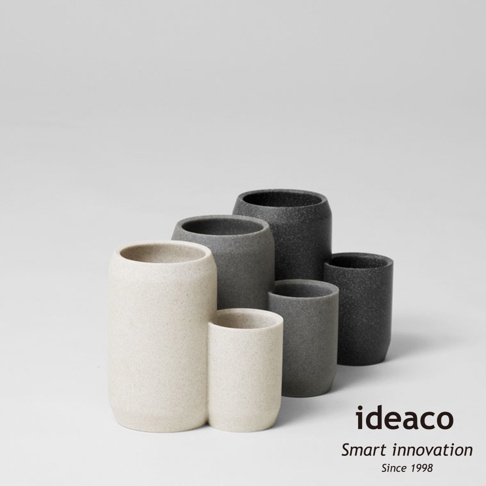 五個不同高度的砂岩材質收納筒，包含兩個淺米色和三個深灰色，呈階梯狀排列。