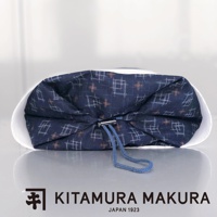 深藍色印花布製成的復古軟管枕，有可調式綁帶，呈現縮口設計。