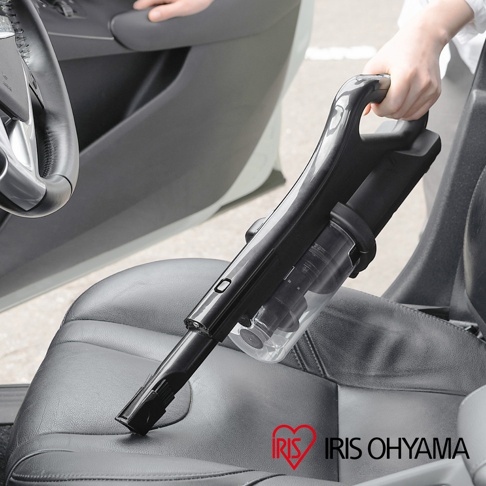 黑色無線充電吸塵器 SCD-185P，配有透明集塵筒，正在清潔汽車座椅。