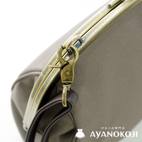 京都口金包品牌 AYANOKOJI 的古董金色金屬扣環與深棕色皮革背帶細節