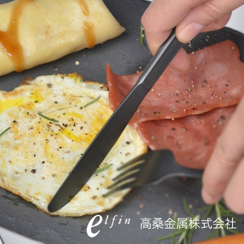日製熔岩黑石餐刀，黑色金屬材質，設計簡約，搭配煎蛋、火腿和可麗餅，呈現精緻早餐場景。