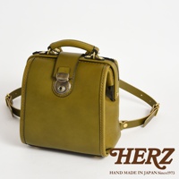 橄欖綠皮革迷你後背醫生包，具有經典醫生包造型，附有金屬旋轉鎖扣和提把，肩帶為皮革材質。