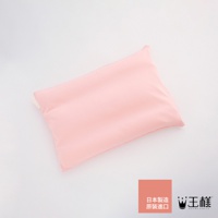 淡粉色枕頭，材質柔軟，表面平整，帶有細微的紋理，角落處有黃色小標籤，右下角有品牌標誌和日文說明。
