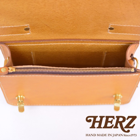 職人手作皮革經典兩用雙扣迷你單肩包，展示了棕色皮革的內裡與外層，以及黃銅色的雙扣和拉鍊。