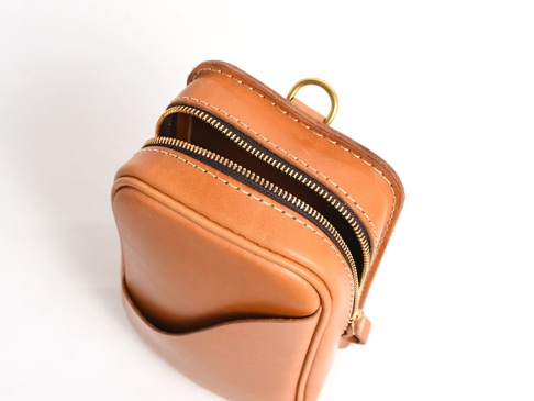 職人手作皮革兩用直立型斜背包，呈現自然棕色皮革，包身方形，頂部有黃銅色拉鍊和 D 型環，側邊有開放式口袋，縫線清晰。