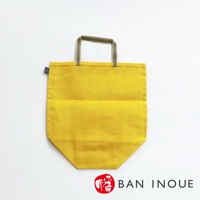 黃色提把蔬果收納袋，材質為織物，袋身呈梯形，提把為條紋織帶。