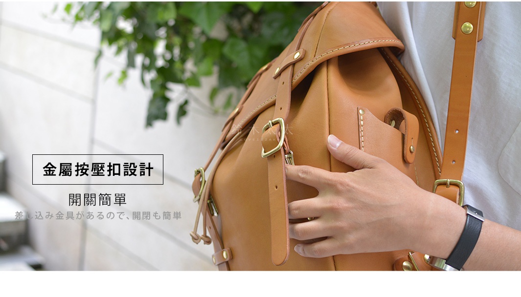 職人手作皮革經典雙扣後背包，呈現原色皮革的自然紋理與質感，搭配黃銅色金屬扣環，設計簡潔大方。