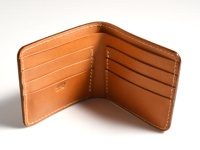 棕褐色皮革雙折短夾，內部有四個卡槽，右側有品牌壓印標誌，縫線為白色。